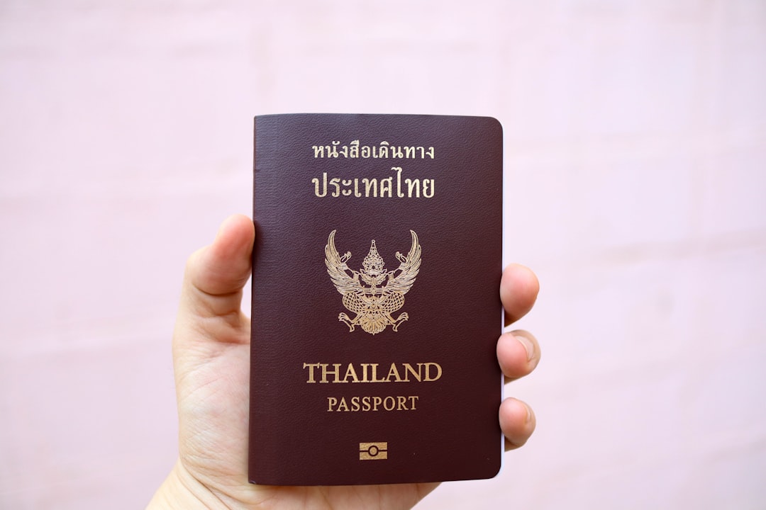 thailand tax documentation — a person holding a Thai passport
